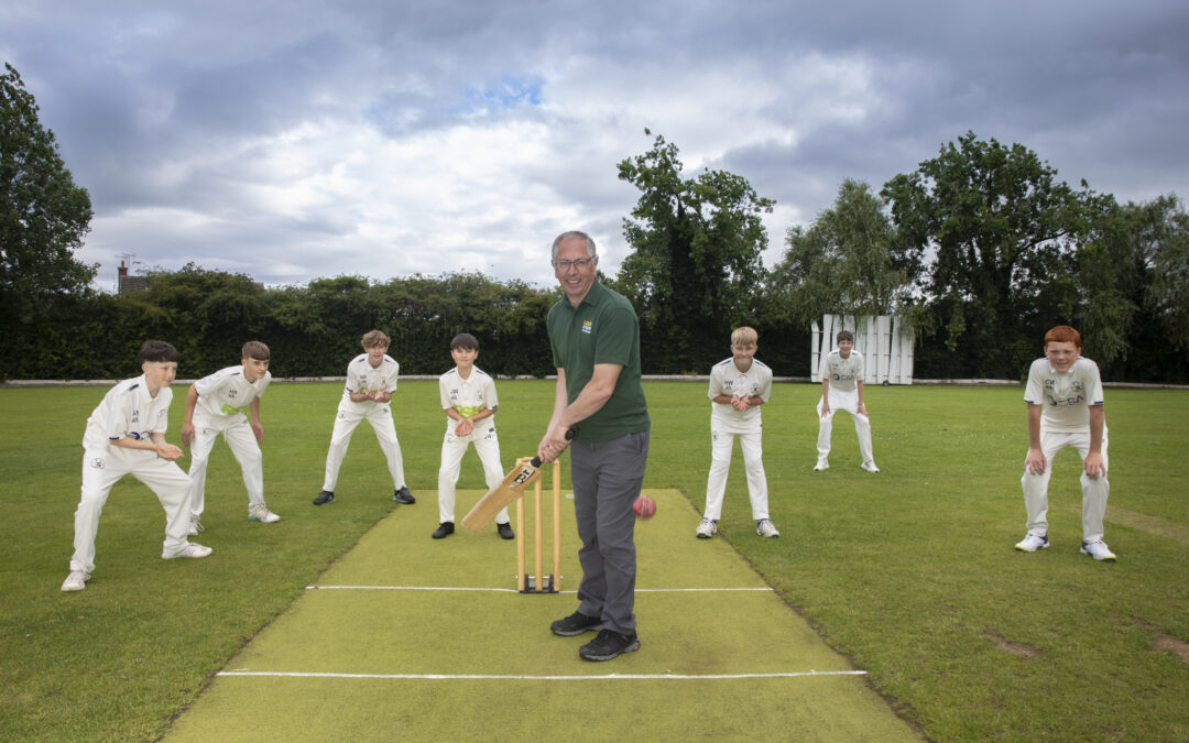 Rob Jones from Lock Stock readies to strike a ball at a cricket crease.